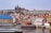 A scenic view of Prague featuring historic buildings and a river.