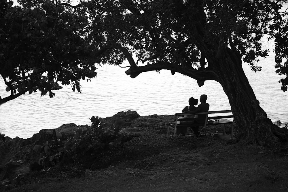 grayscale photography of couple sitting on bench