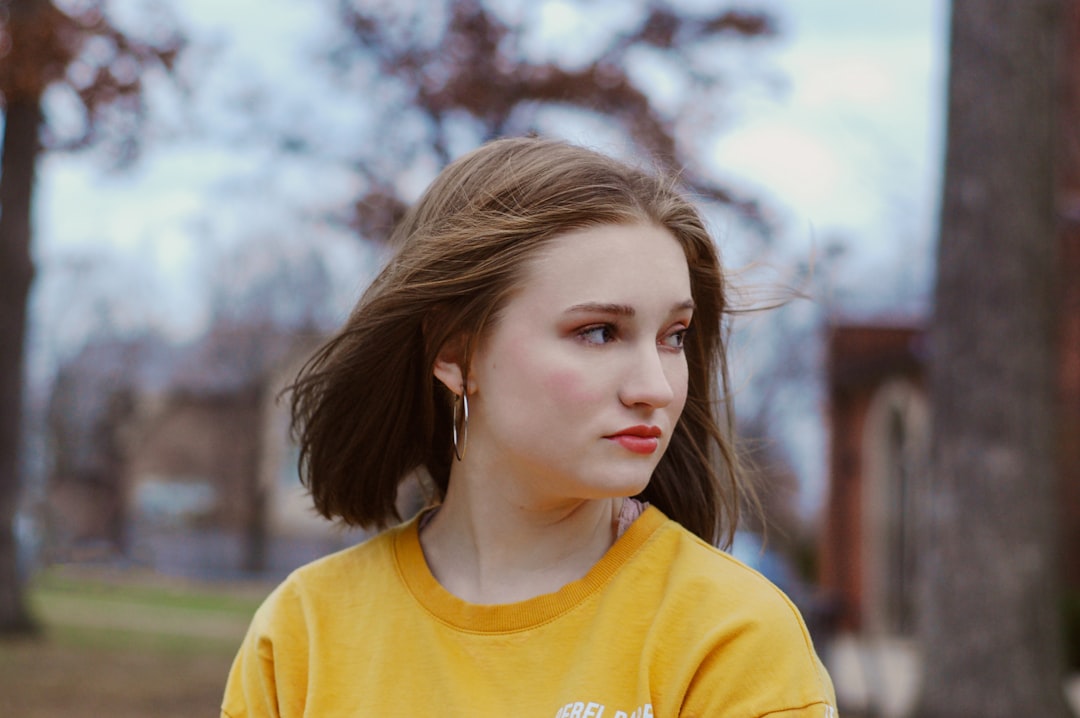 selective focus photography of woman wearing yellow crew-neck shirt