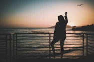 silhouette of woman standing near the fence