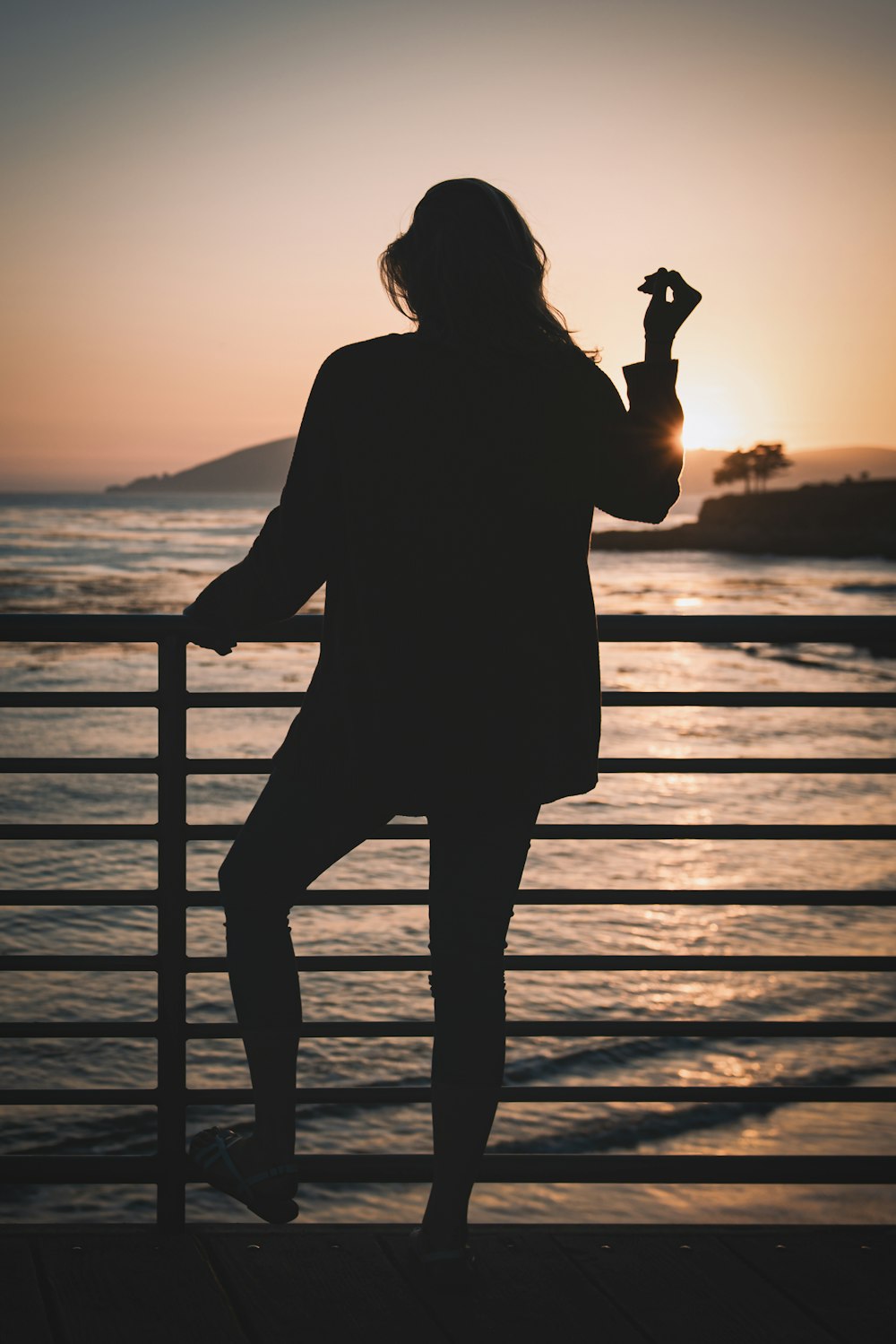 silhouette of woman standing near railings