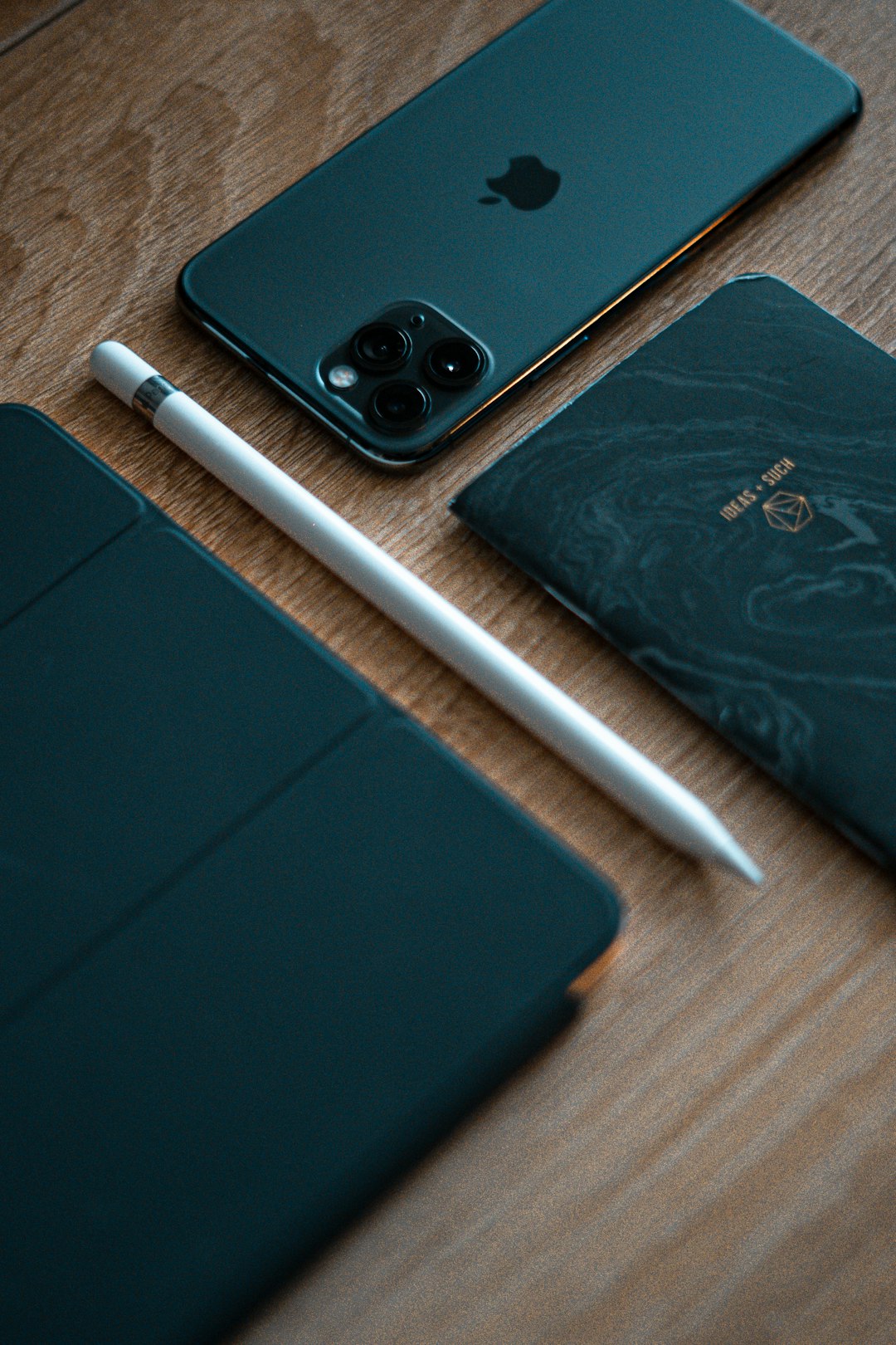 white stylus pen beside space gray iPhone 11 Pro and passbook