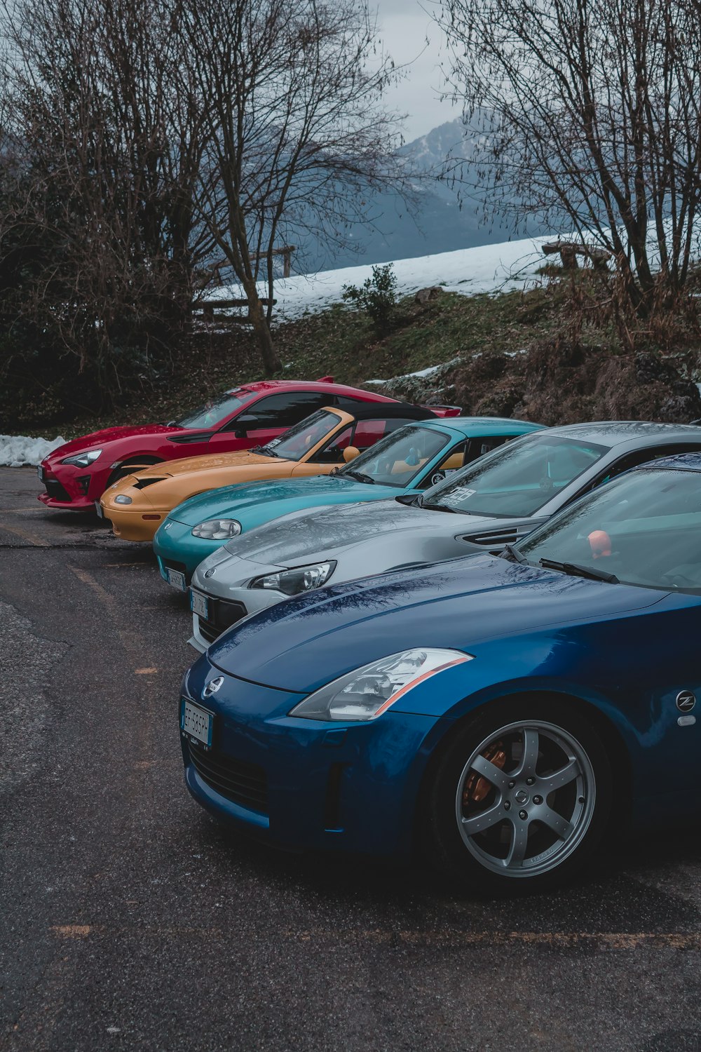 Cinco vehículos de colores variados en la carretera