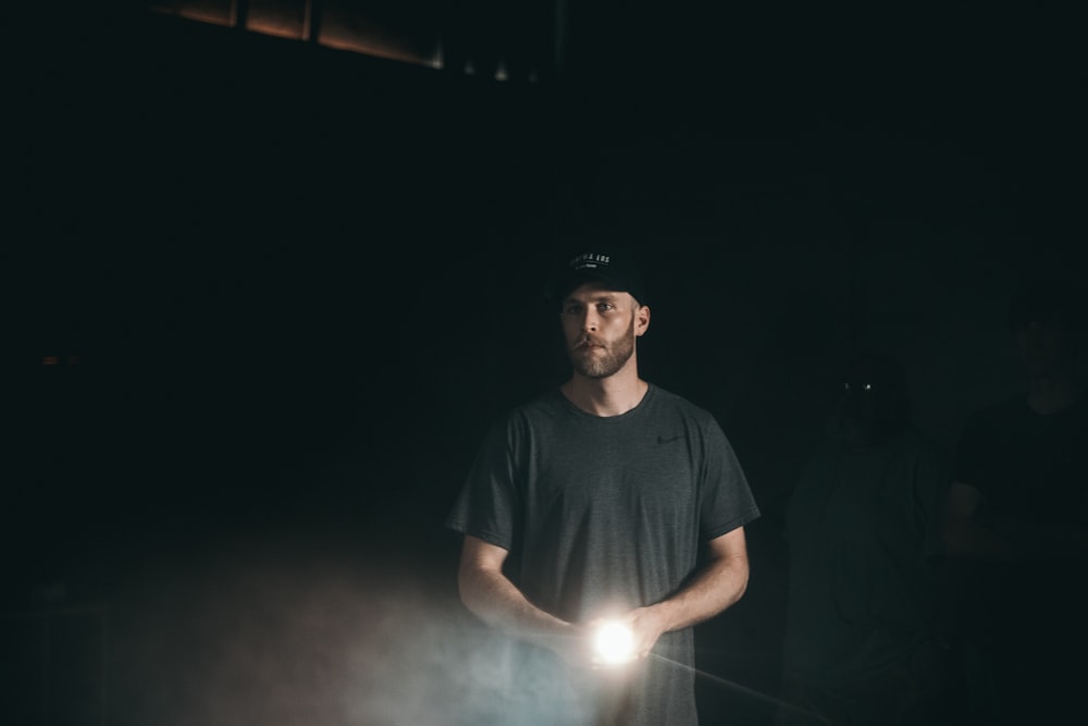 man holding a turned on flashlight