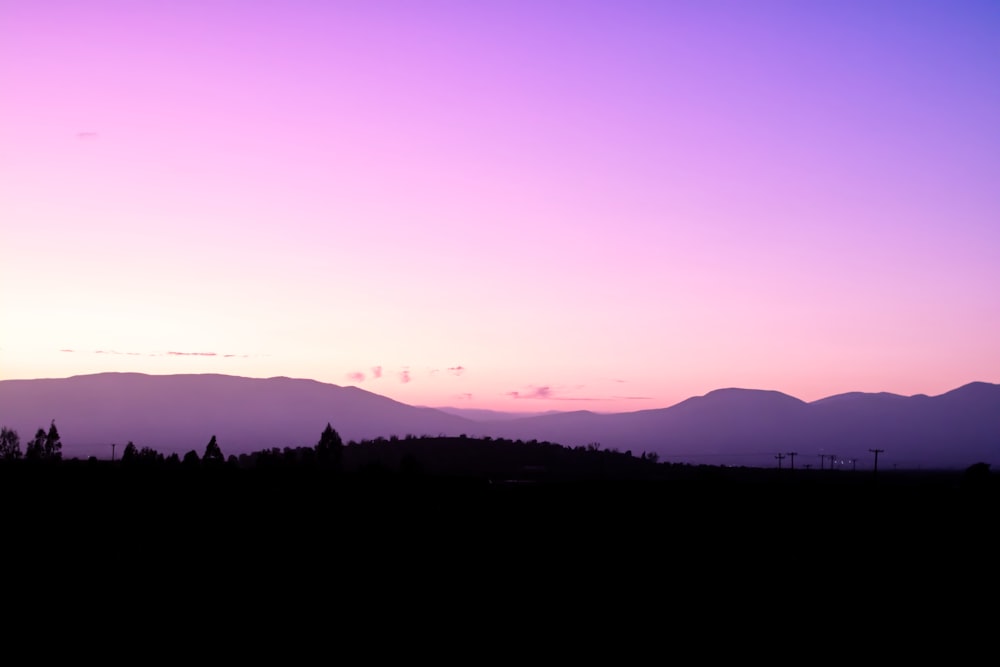 silhouette photography of land under a purple sky during daytime