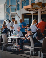 Friends gathered around a table on a cruise ship, sharing stories and local cuisine during a lively evening.