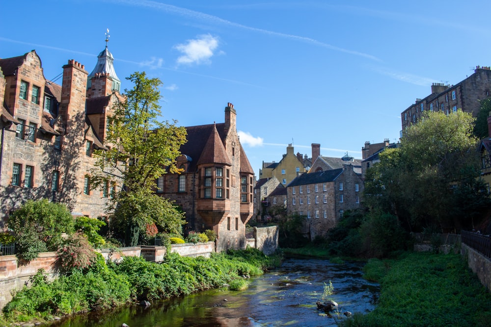 houses beside a water sewage under a calm blue sky during daytime