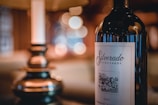 A close-up of a wine bottle labeled 'Silverado Vineyards' with a blurred and warm ambient background featuring a lamp. The label indicates a 2007 Cabernet Sauvignon.