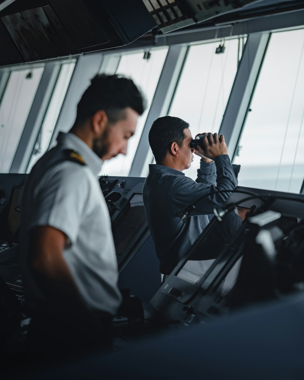 two men standing at a ship's control rom