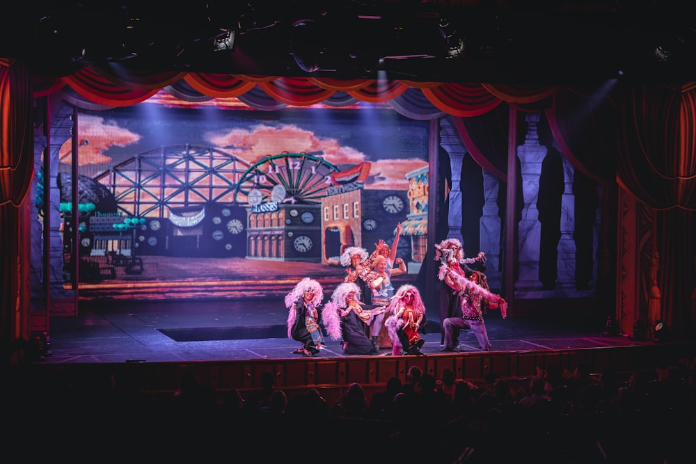 multidão de pessoas assistindo a uma apresentação de palco no teatro