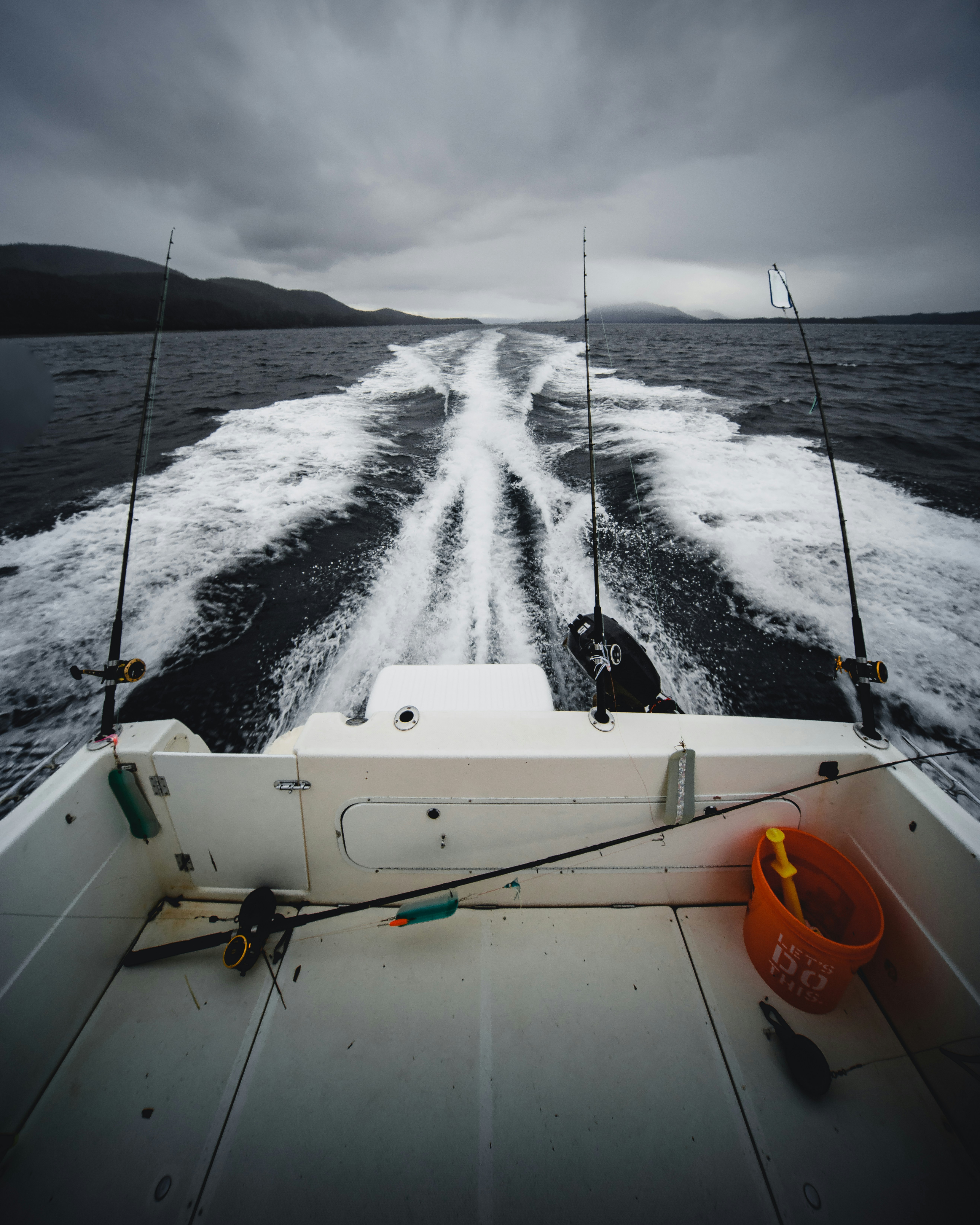 fishing rods on speeding boat during day
