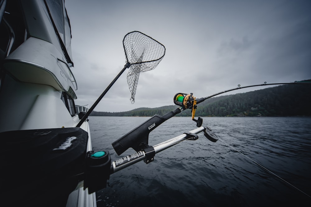 Fishing rod and net hanging from a boat in the sea photo – Free Grey Image  on Unsplash