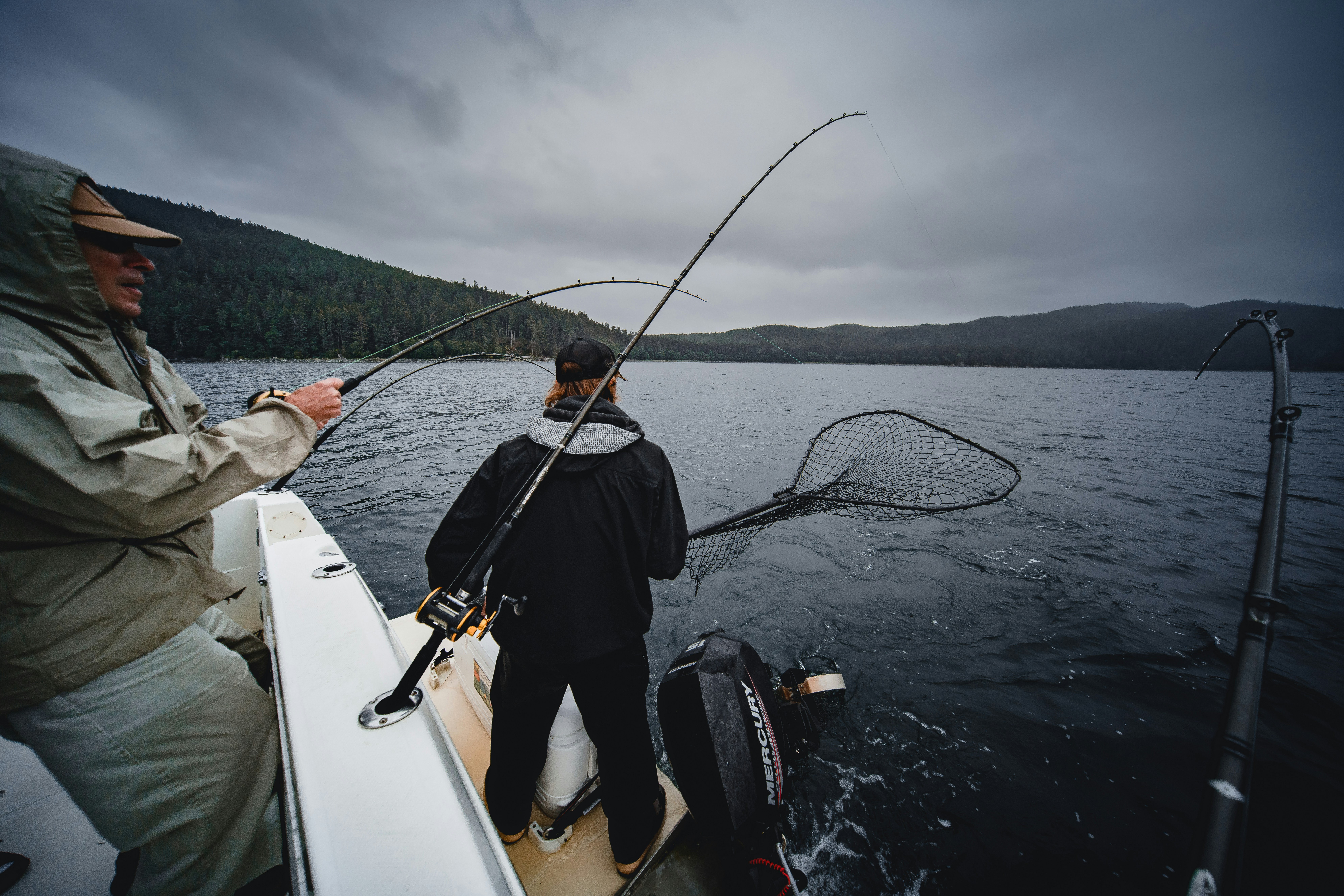 men fishing under cloudy sky