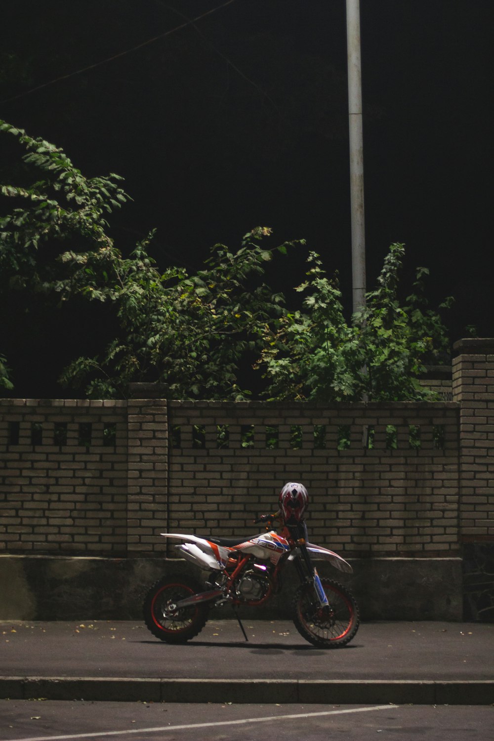 dirt bike by concrete wall at nighttime