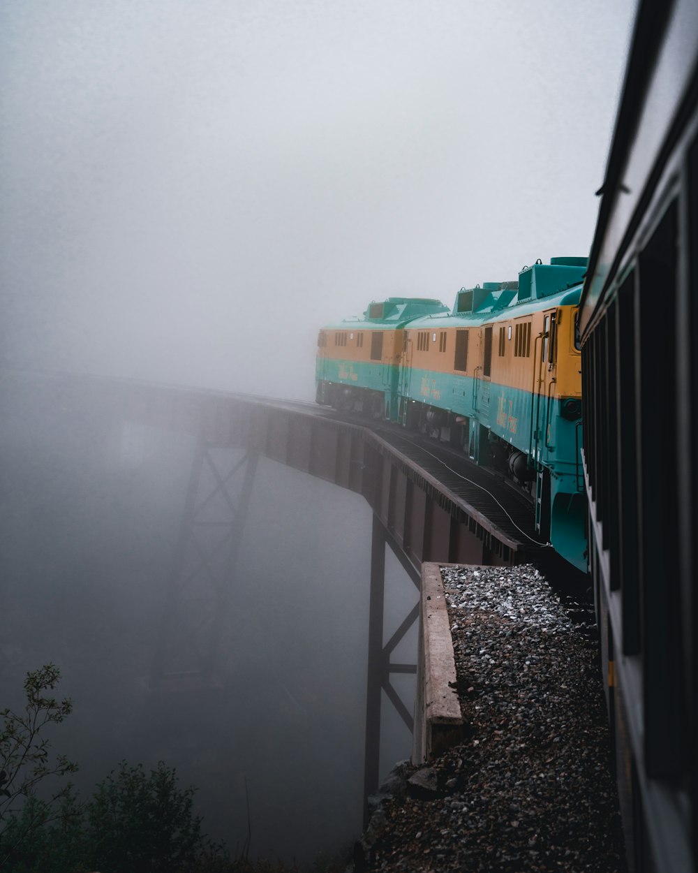 train on track about to cross a bridge during foggy weather