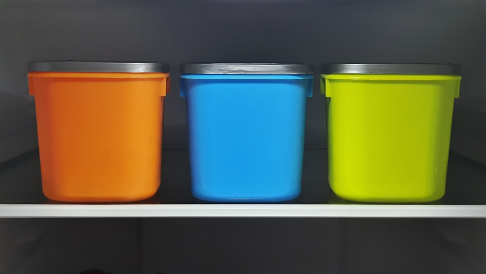 recipientes plásticos laranja, azul e verde