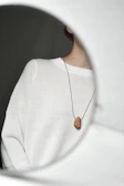 An everyday necklace layered over a cozy cream sweater.