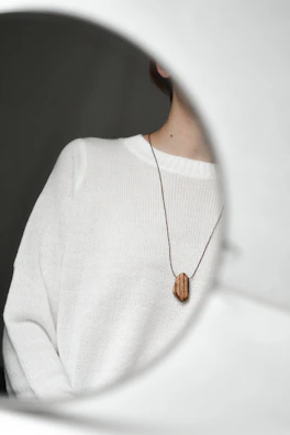 An everyday necklace layered over a cozy cream sweater.