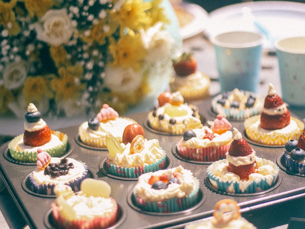 cupcakes sur plateau à côté du centre de table des fleurs