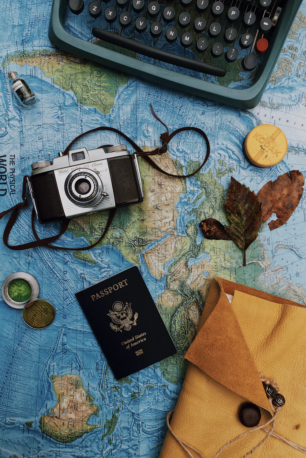 Flat lay of a camera, laptop and passport, planning a trip