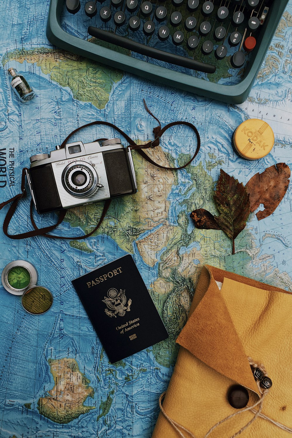 Fotografia flatlay di macchina fotografica, laptop e passaporto