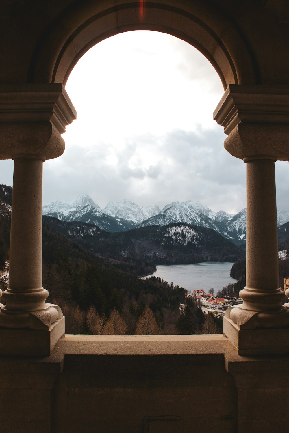 una vista di un lago attraverso un arco in un edificio