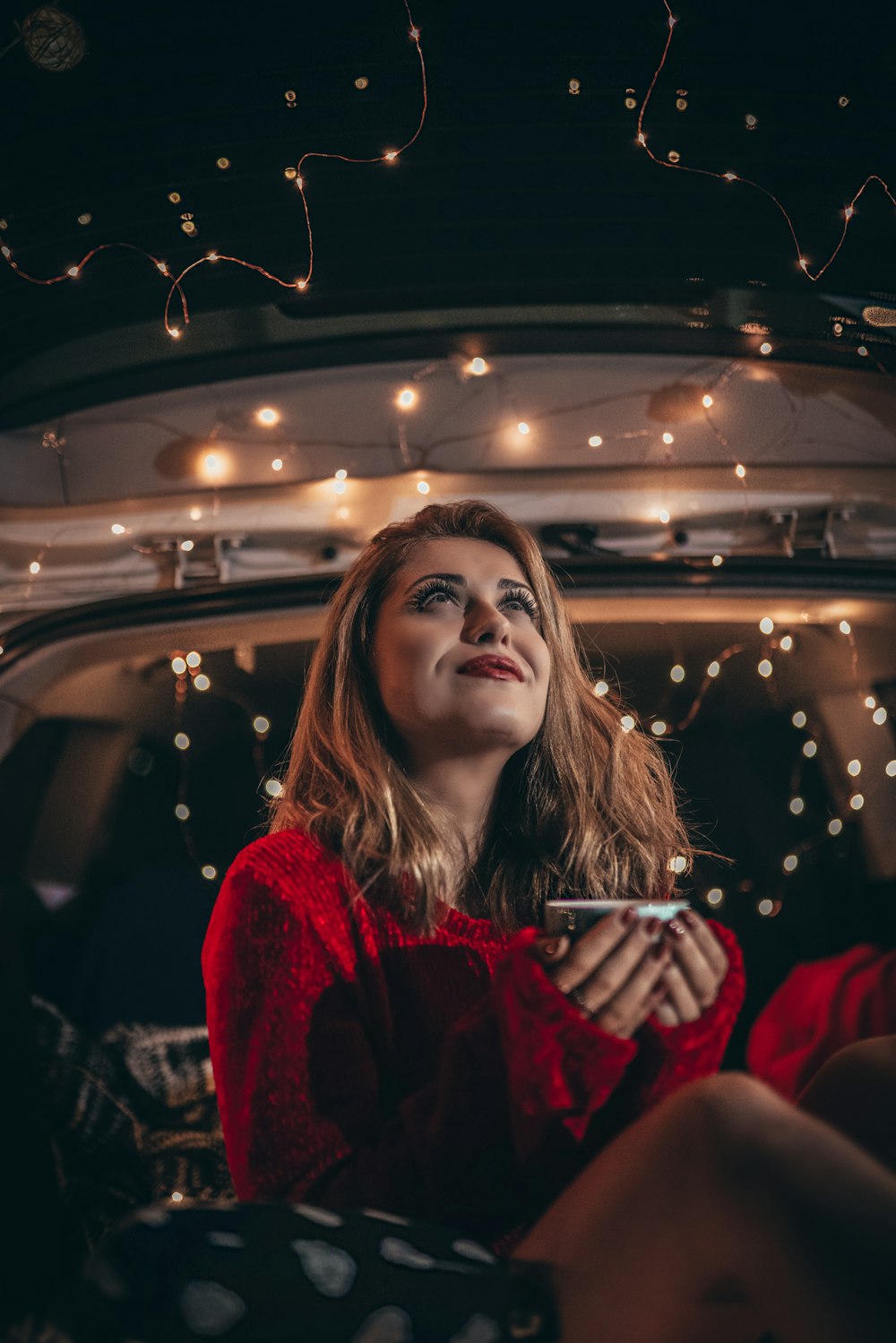 woman in red jacket sitting in car