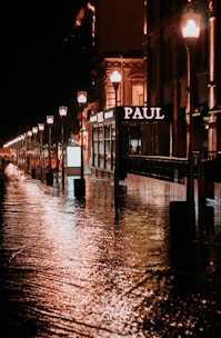 a city street is flooded with water at night