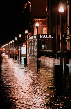 a city street is flooded with water at night
