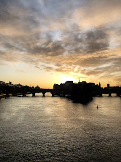 A serene image of the river flowing beneath the iconic bridge of the sanctuary at sunset.