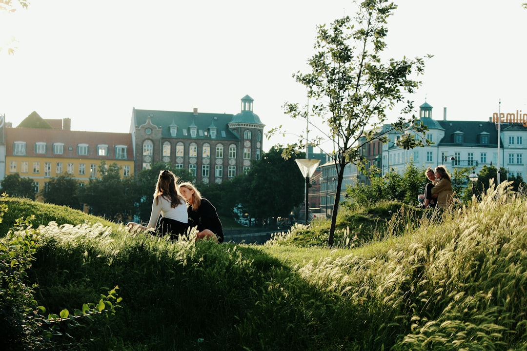 two women sitting on green grass, Beautiful park in Copenhagen 🇩🇰