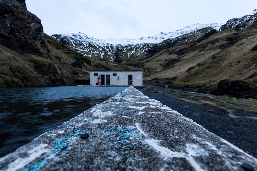 a small white building sitting on the side of a river