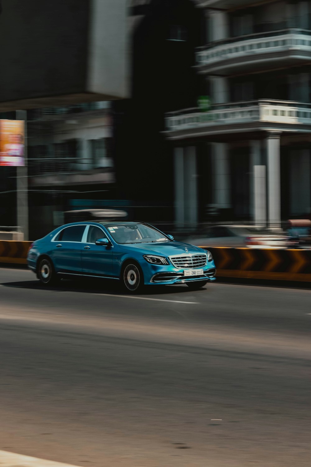 panning photography of blue sedan on road