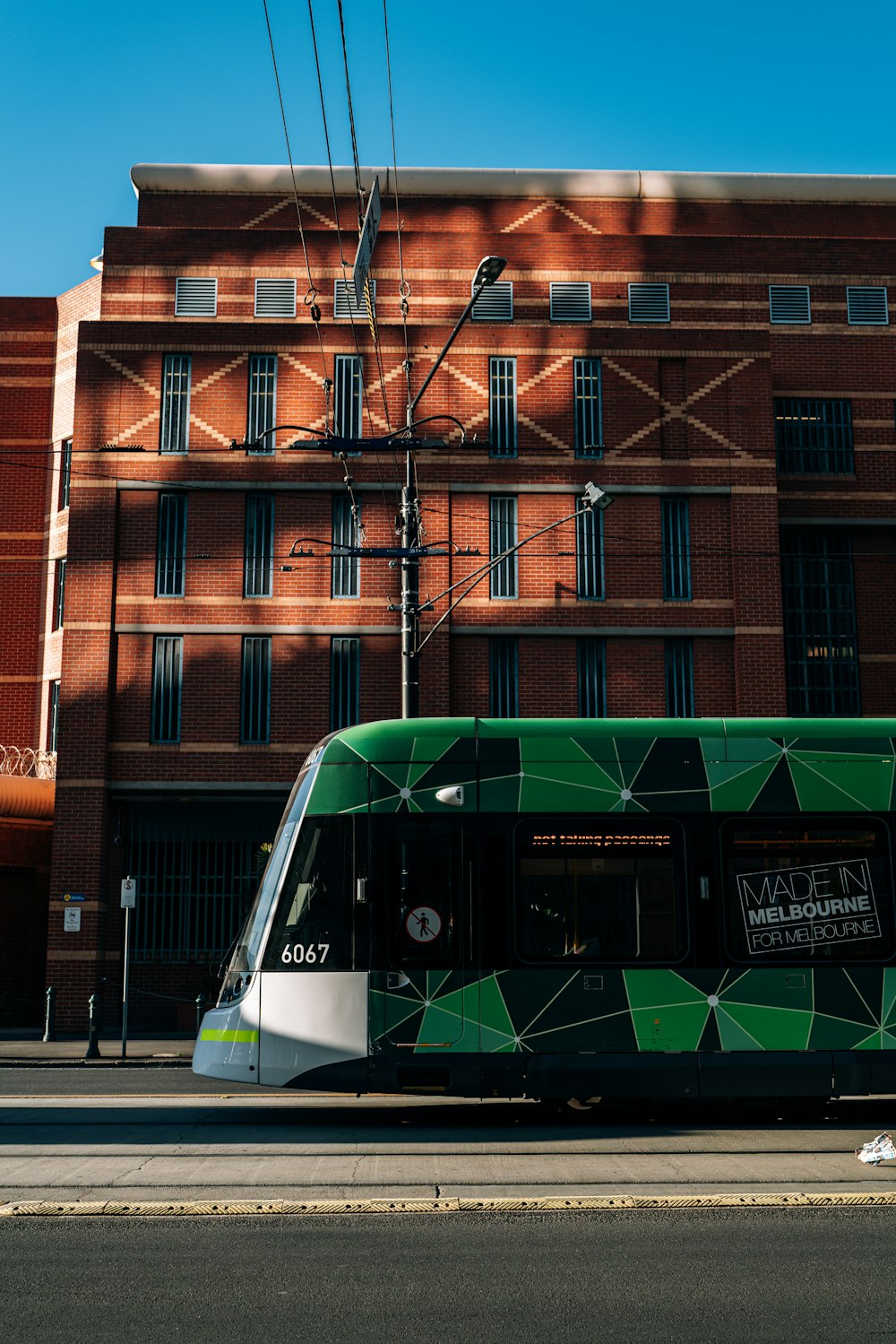 a green and white bus parked in front of a building