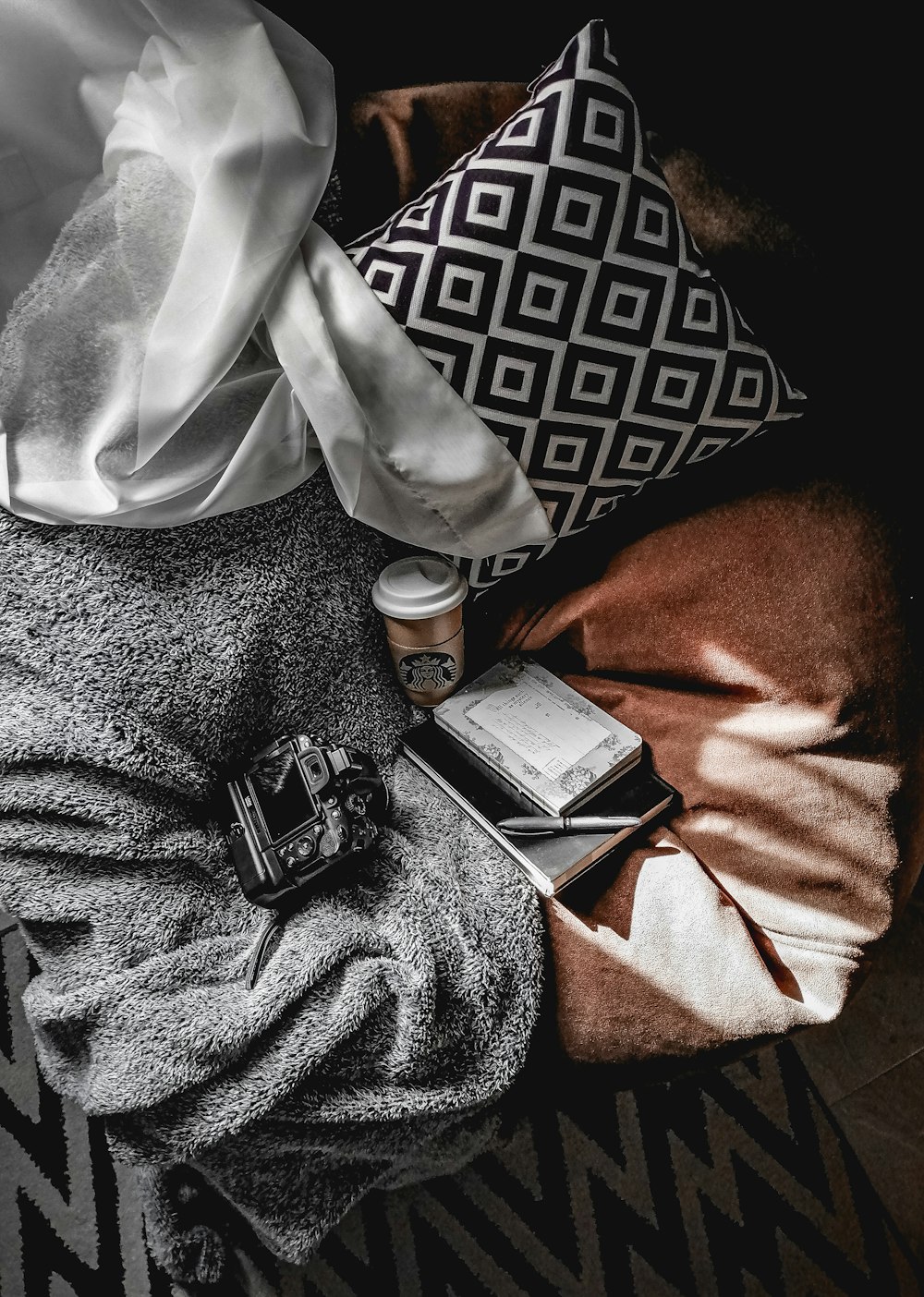 a black and white photo of a blanket and pillows