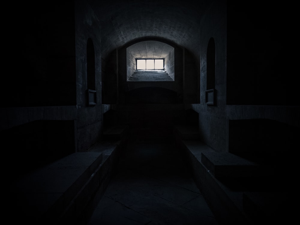 a dark tunnel with a window in it