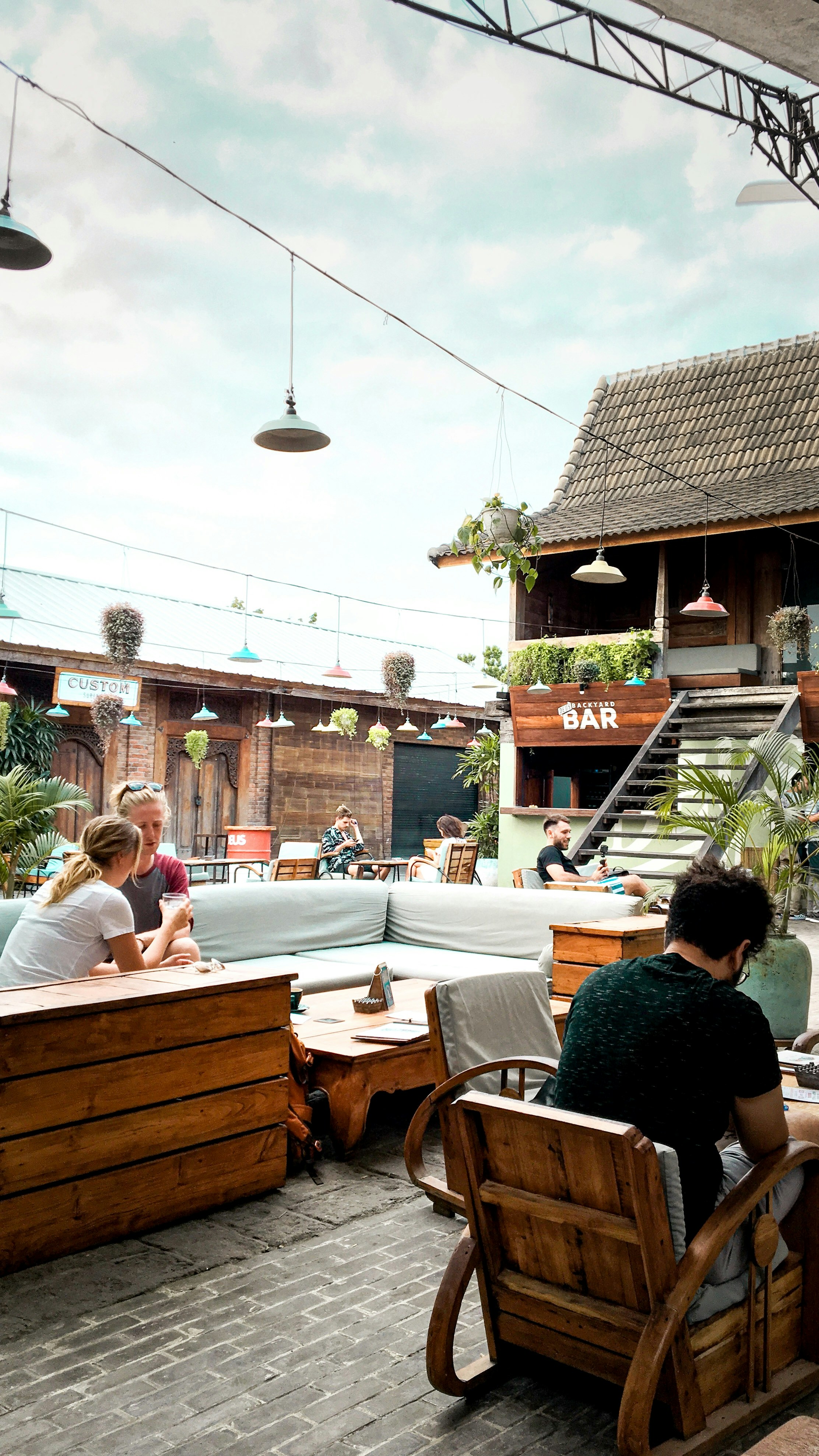 people sitting on brown wooden chairs during daytime