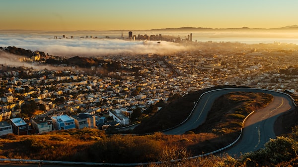 A view of a city from a hill above the clouds