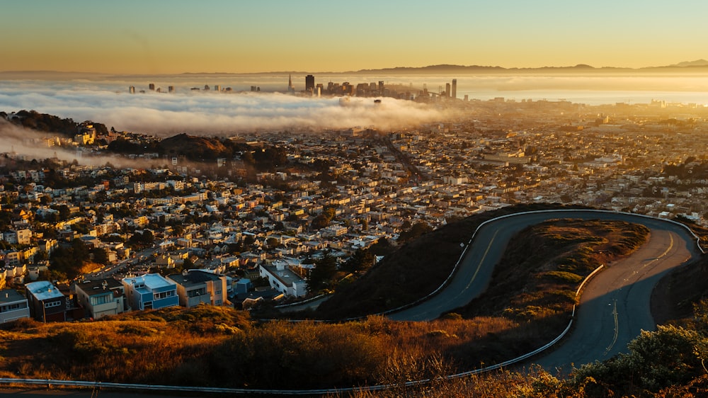 a view of a city from a hill above the clouds