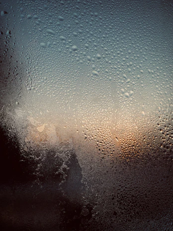 Close-up of a freshly cleaned window pane with water droplets drying in the sun.