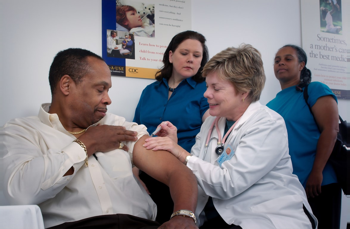 Image of a medical professional giving a man a shot in the arm
