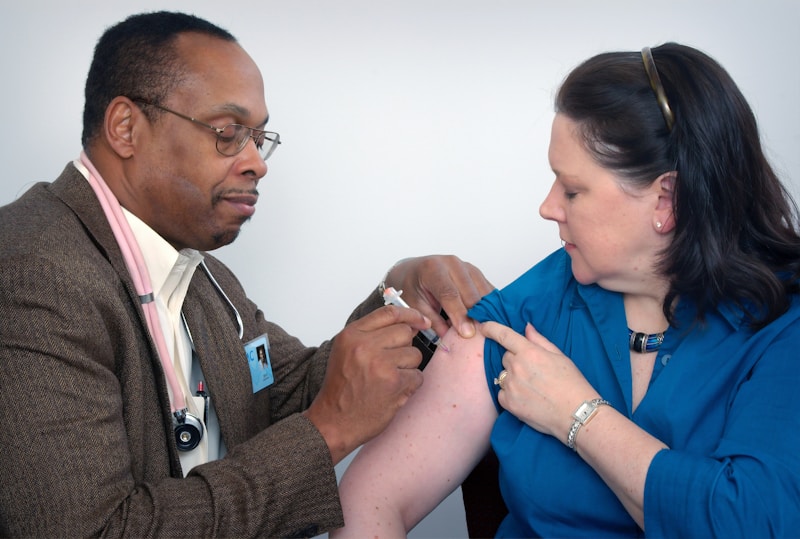 man inject woman on right arm