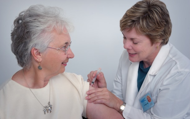 woman inject a woman on left shoulder