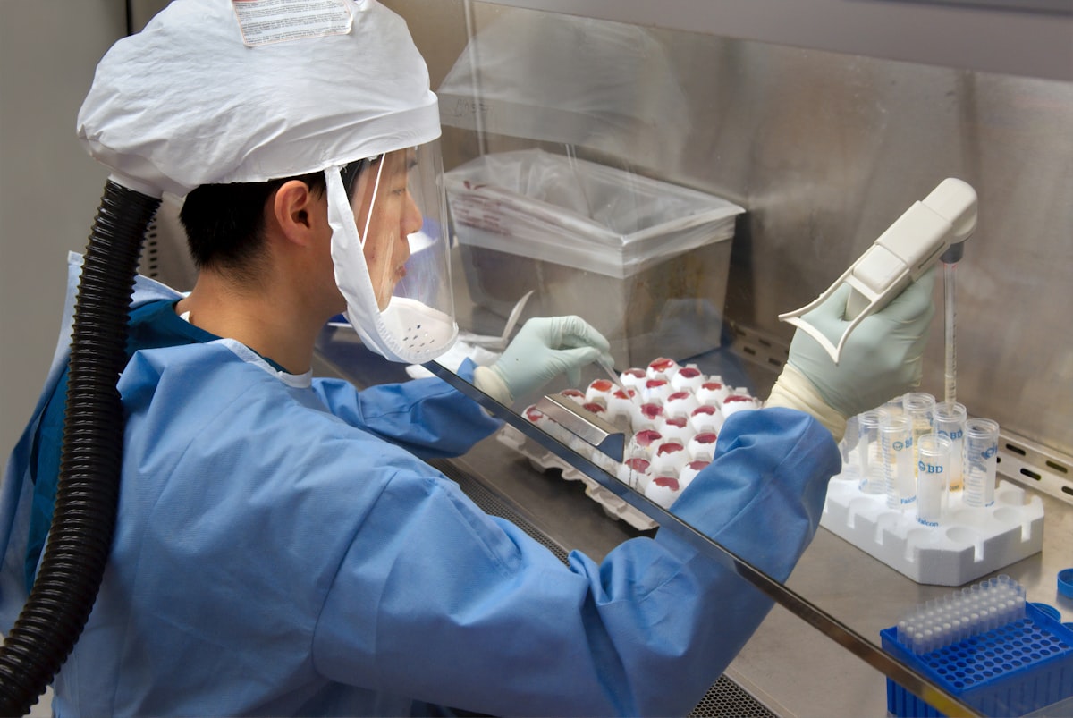 Scientist working inside a laboratory wearing full protective equipment including gloves and safety goggles