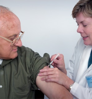 woman injecting syringe on mans arm