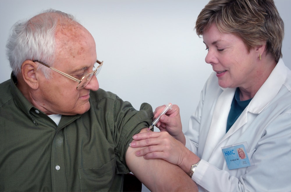 mujer inyectando jeringa en el brazo del hombre