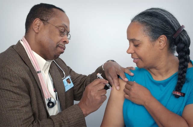 man doing syringe on woman wearing blue shirt