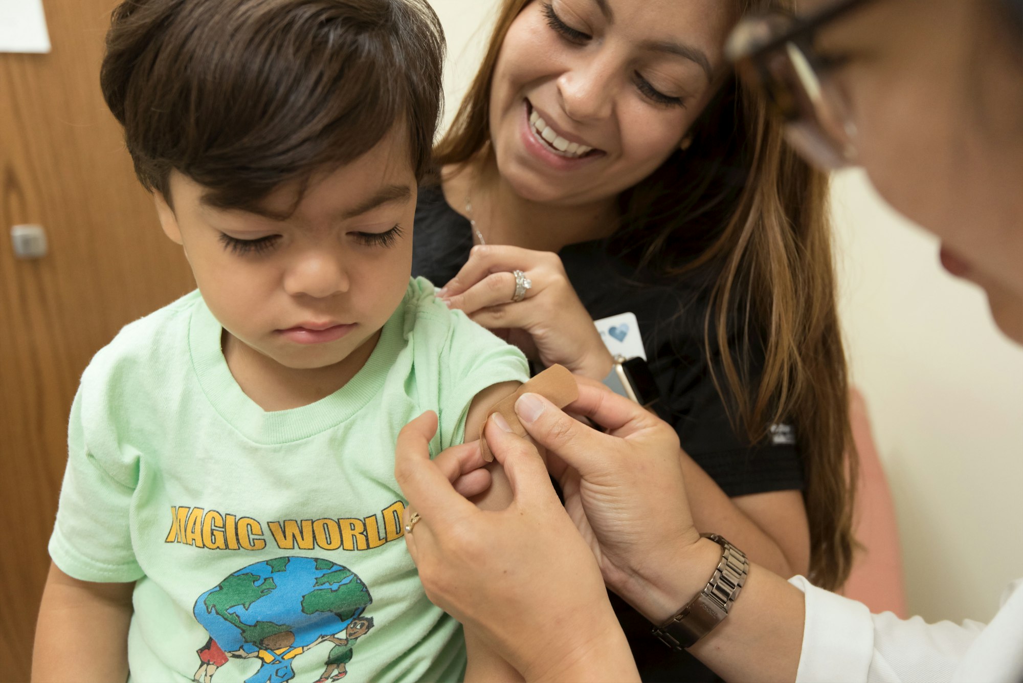 In this 2017 photo, captured inside a clinical setting, a health care provider was placing a bandage on the injection site of a child, who had just received a seasonal influenza vaccine. Children younger than 5-years-old, and especially those younger than 2-years-old, are at high risk of developing serious flu-related complications. A flu vaccine offers the best defense against flu, and its potentially serious consequences, and can also reduce the spread of flu to others.