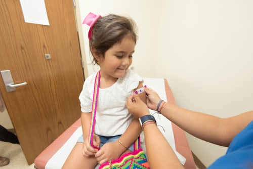 Child with band aid after receiving vaccine