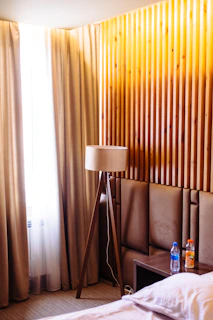 A warm, softly lit living room showcasing a modern indoor lamp on a wooden side table.